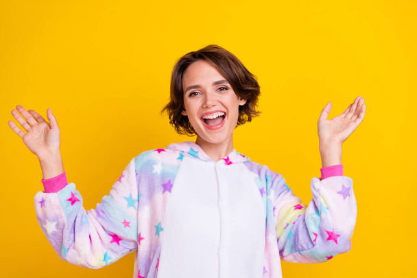 Photo of young cheerful girl happy positive smile have fun wear pajama bedtime isolated over yellow color background - Valokuva, kuva