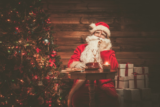 Άγιος Βασίλης με τηλέφωνο στο ξύλινο σπίτι εσωτερικό  - Φωτογραφία, εικόνα