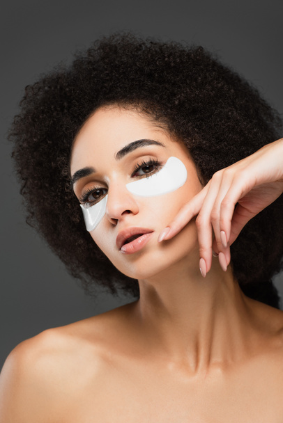 young african american woman in eye patches posing with hand near face isolated on grey - Foto, Imagem