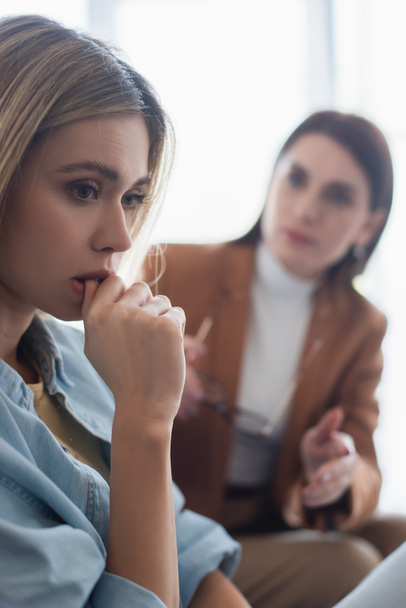 frustrated woman near blurred psychologist in consulting room - Foto, Imagen