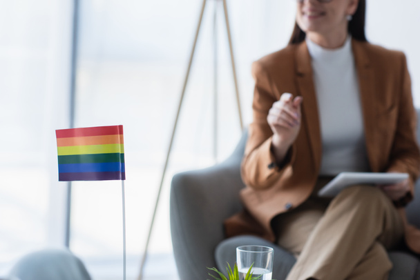 small lgbt flag near cropped psychologist with digital tablet on blurred background - Valokuva, kuva