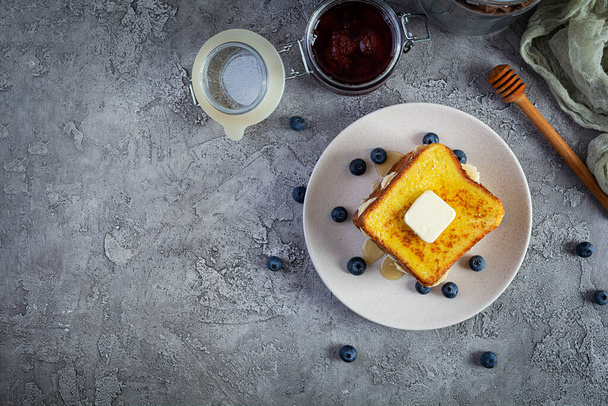 French toast with banana, blueberry, honey and strawberry jam. Delicious morning breakfast or brunch with toast and cookies. Top view - Фото, зображення