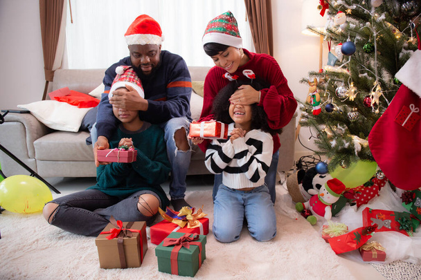Mutlu aile babaları ve anneleri göz açıp kapayıncaya kadar evlerinde Noel kutlaması için hediye kutuları veriyorlar. Aileleri evde sürpriz çocuklar, Şükran Günü arifesi, mutlu noeller.. - Fotoğraf, Görsel