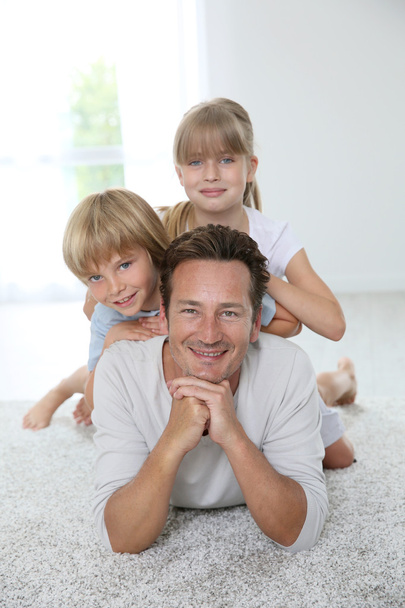 Daddy with kids laying on carpet - Foto, afbeelding