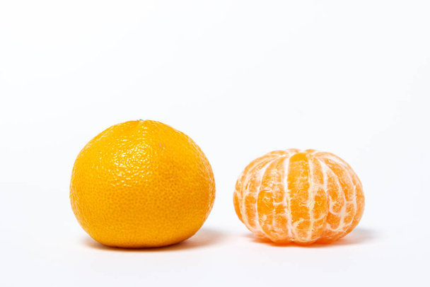 Na bílém pozadí oloupané a neoloupané mandarinky. Izolovaný mandarinka - Fotografie, Obrázek