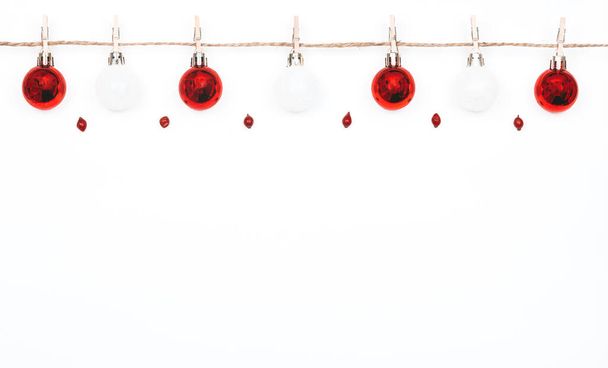 Noel beyaz arka planı ve oyuncak topları. Mandallı doğal iplik ve kırmızı Noel topları. Noel kırmızı topları - Fotoğraf, Görsel