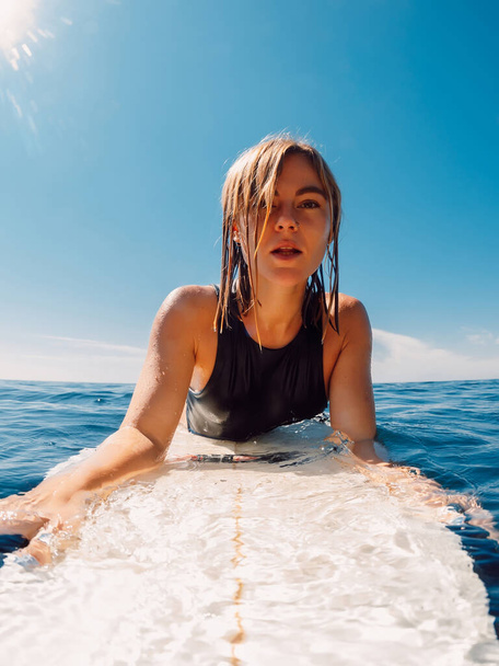 Portrait of surf girl on surfboard. Beautiful blonde woman during surfing. Surfer in ocean - Fotografie, Obrázek