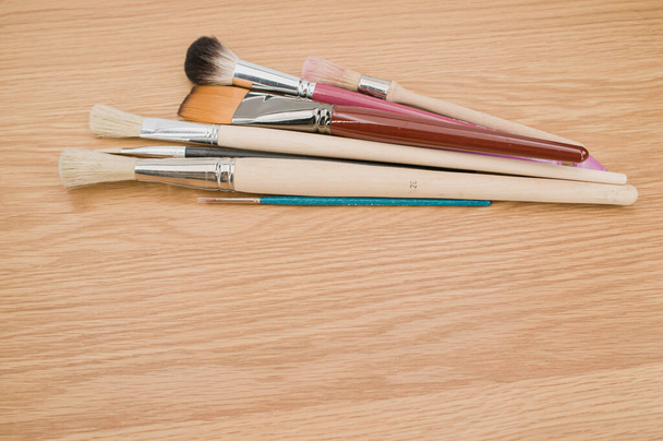 set of paintbrushes on a wooden tabletop with copy space - Foto, Imagem