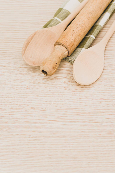 natural wood kitchen utensils and a table napkin on a wooden background with copy space - Fotoğraf, Görsel