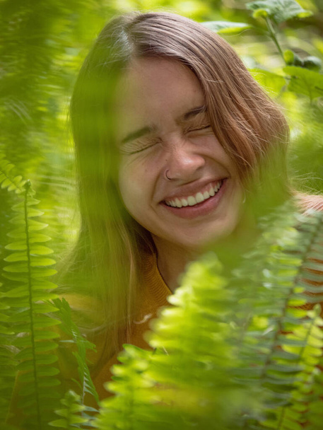 An attractive young girl laughing in a forest - Fotoğraf, Görsel