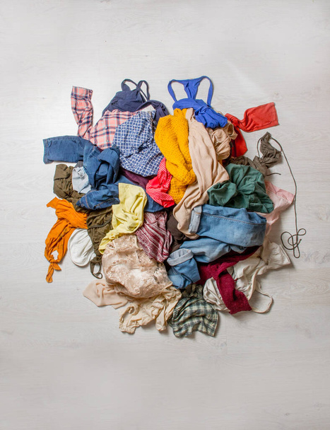 pile of used clothes on a light background. Second hand for recycling - Фото, изображение