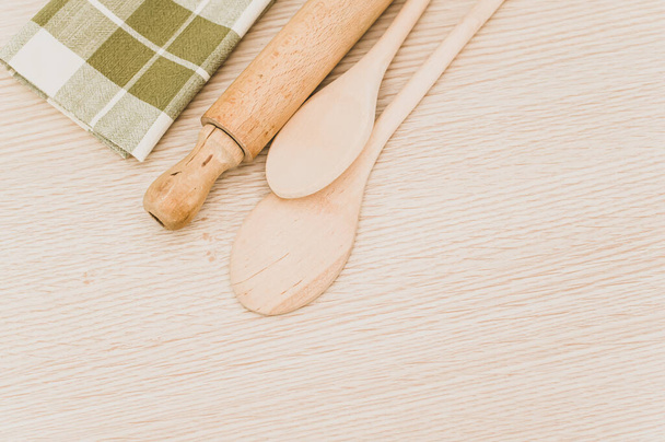 natural wood kitchen utensils and a table napkin on a wooden background with copy space - Fotoğraf, Görsel