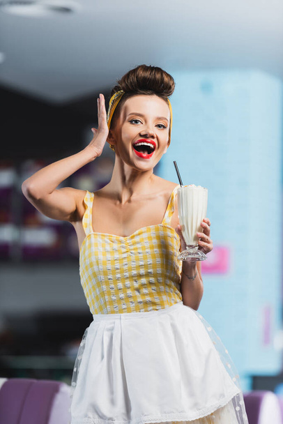 astonished pin up woman with tattoo holding milkshake  - Zdjęcie, obraz
