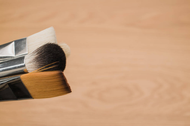 set of paintbrushes on a wooden tabletop with copy space - 写真・画像