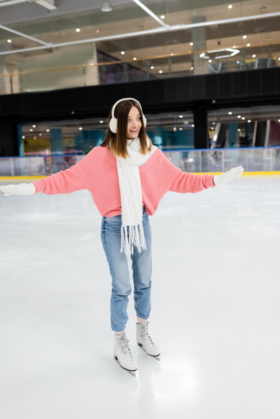 full length of astonished woman in winter outfit skating on ice rink - Photo, Image