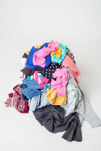 pile of used clothes on a light background. Second hand for recycling - Φωτογραφία, εικόνα