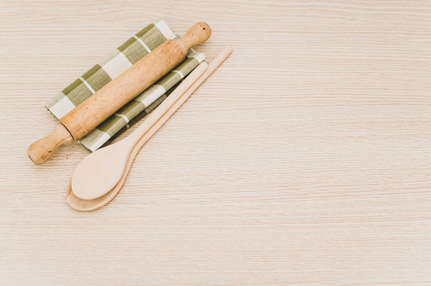 natural wood kitchen utensils and a table napkin on a wooden background with copy space - 写真・画像