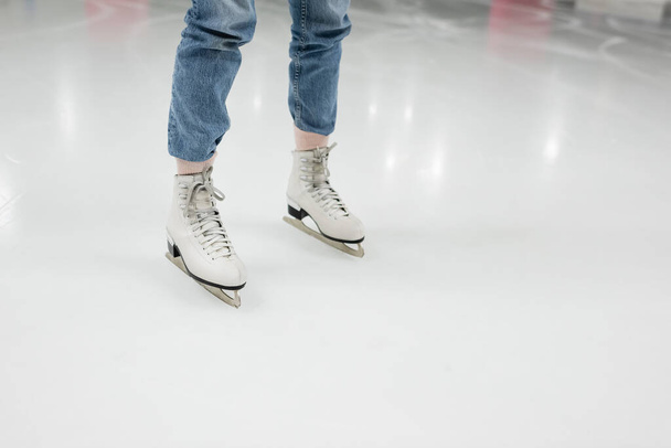 partial view of young woman in jeans skating on ice rink  - Foto, Imagem