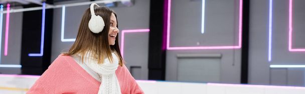 positive woman in pink sweater and white ear muffs, banner - Фото, зображення