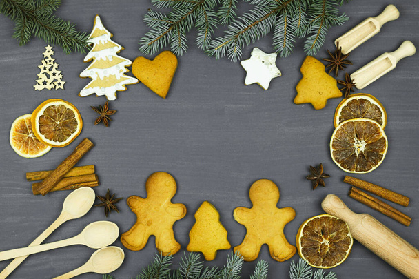 Weihnachtsbäckerei Hintergrund mit Zutaten zum Kochen. Tannenzweige, Lebkuchen, Männchen. Mehl, Gewürze, Spielzeug von oben. - Foto, Bild