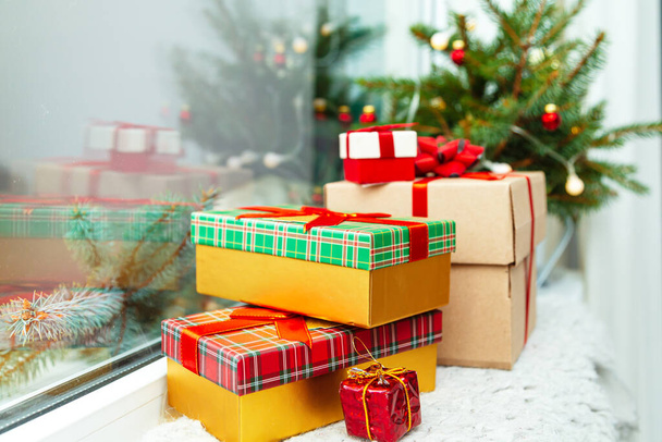 Christmas and New Year decorations. Gift boxes, fir branches, garland on the windowsill. Cozy Christmas.  - Photo, Image