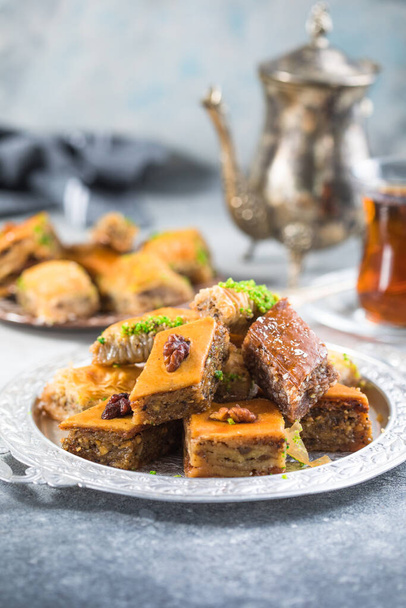 Традиційні турецькі десерти Баклава з чаєм. Мішанина баклава на срібній тарілці. - Фото, зображення