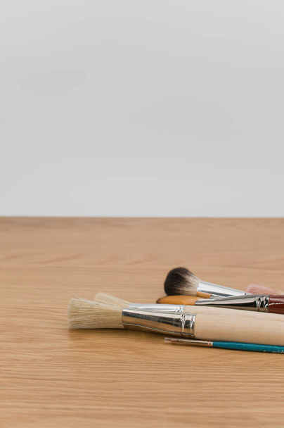 set of paintbrushes on a wooden tabletop with copy space - Foto, Imagem
