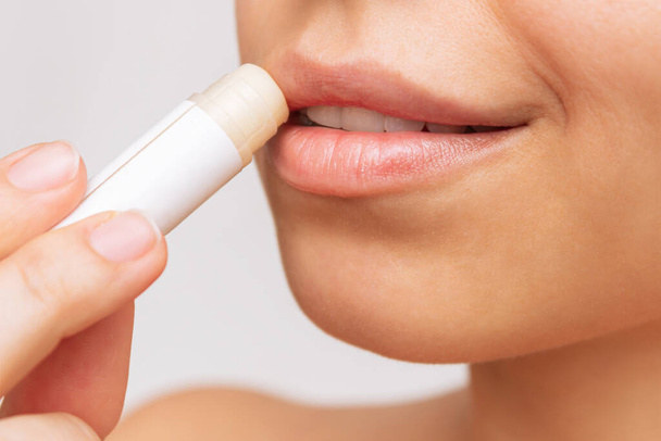 young woman applying cosmetic lipstick on her lips - Photo, Image