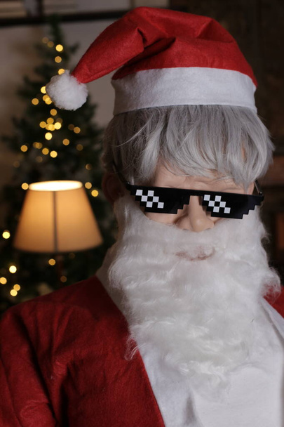 portrait de personne en costume de Père Noël et lunettes de soleil stylisées 8 bits à l'intérieur - Photo, image