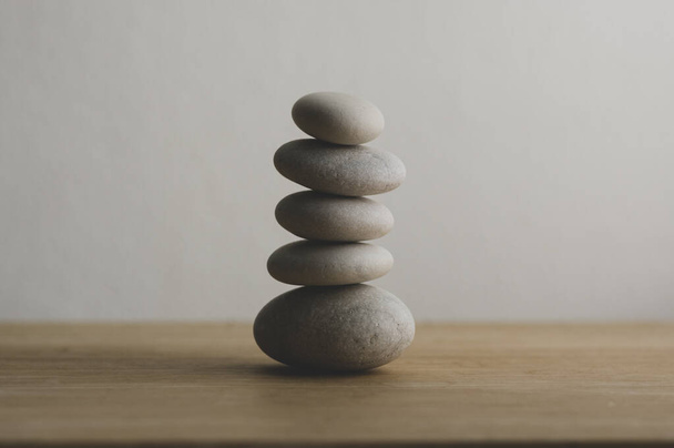 Stone cairn on white background, five stones tower, simple poise stones, simplicity harmony and balance, rock zen sculpture tower - Φωτογραφία, εικόνα
