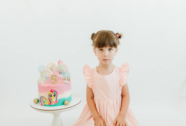 Jolie petite fille fête son anniversaire de cinq ans. Joyeux petite fille célébrant sa fête d'anniversaire, s'amuser. Beau gâteau avec poney - Photo, image