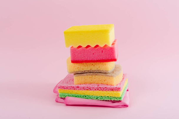 Színes edény mosás szivacs és mosás a rózsaszín háttér. - Fotó, kép