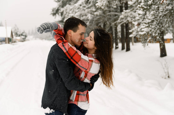 Loving couple in shirt on a winter walk. Man and woman having fun in the frosty forest. Romantic date in winter time.Christmas mood of a young family.Winter lovestory - Foto, immagini