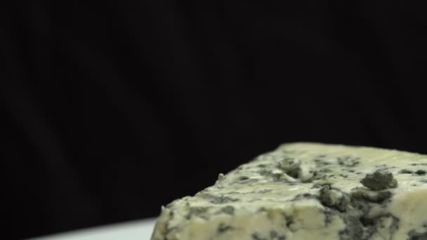 Tuoksuvia sinisiä juustoja ja jaloa hometta. Sinihomejuuston koostumus. Sininen jalo sinihomejuusto pyörii lautasella. - Materiaali, video
