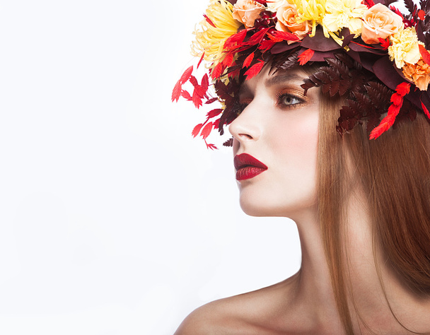 Beautiful red-haired girl with bright autumn wreath of leaves and flowers. Beauty face. - Fotografie, Obrázek
