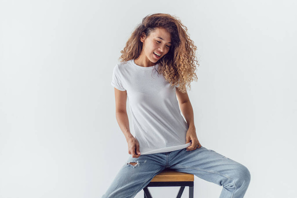 Attractive woman with lush curly hair wearing a white t-shirt. Mock-up. - Photo, image