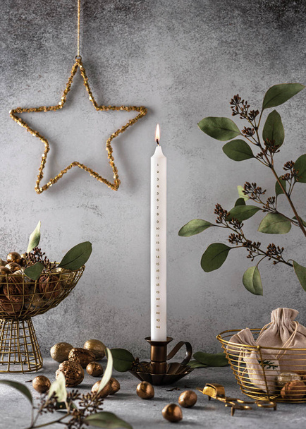 Advent burning candle with countdown December 24 date before Christmas celebration. Old tradition and home decoration concept. Copy space. - 写真・画像