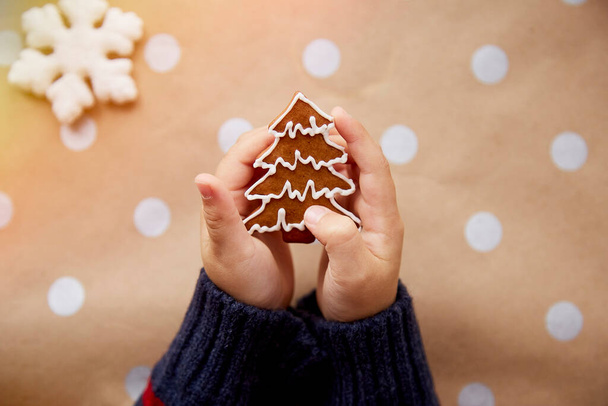 Christmas homemade christmas tree cookies in child hands among festive Christmas decorations. Aesthetic Christmas atmosphere, home coziness and warmth concept. High quality photo - Photo, Image