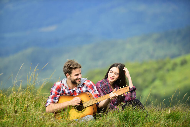 true love. men play guitar for girl. couple in love spend free time together. western camping. hiking adventure. happy friends with guitar. friendship. campfire songs. country music. romantic date - Фото, изображение