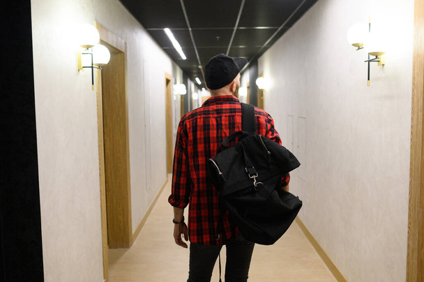 Mid adult man arriving to hotel and going to the room while pulling his suitcase through the lobby - Fotografie, Obrázek