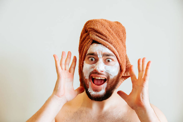 shouts, scared and messy man applying beauty facial mask looking at camera - Fotoğraf, Görsel