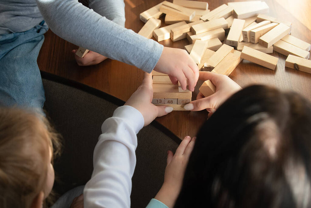 Children at home play board game with Jenga sticks - Фото, зображення