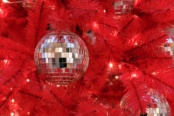 Boule de Noël disco sur un sapin de Noël rouge. - Photo, image