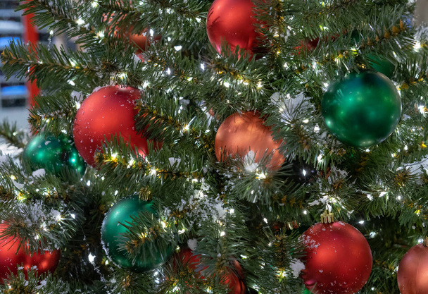 Červené a zelené vánoční koule na vánočním stromečku s věncem. - Fotografie, Obrázek
