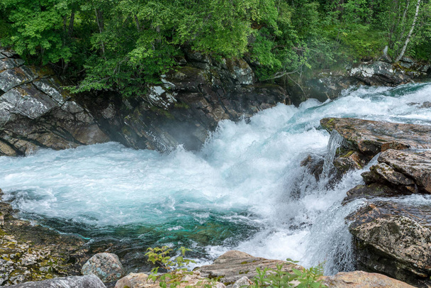 Creek no alto das montanhas norueguesas com água azul-turquesa fresca que flui rapidamente através de rochas - Foto, Imagem