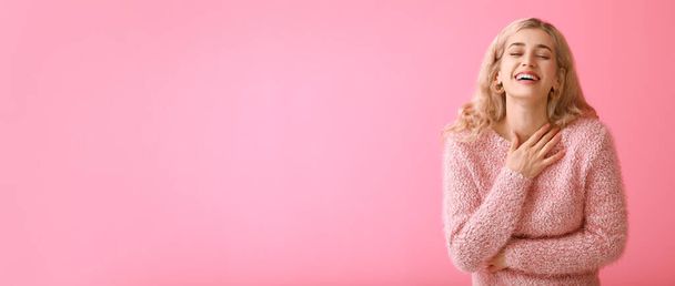 Счастливая молодая женщина в теплом свитере на цветном фоне с пространством для текста - Фото, изображение