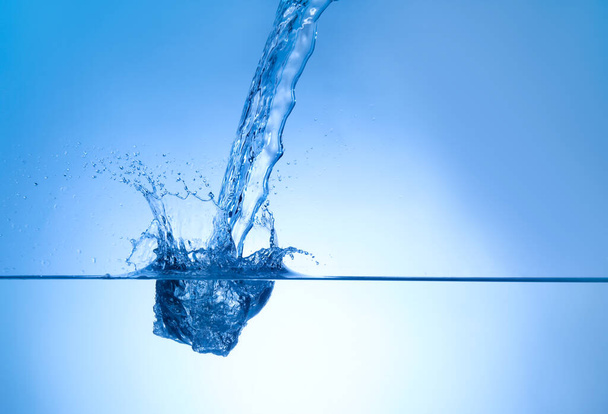 Splash of water on blue background - Foto, afbeelding