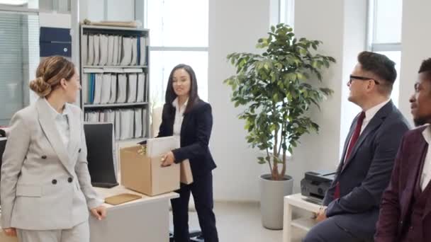 Ruční sledování záběr šťastný jistý businesswoman v obleku vyzvednutí lepenkové krabice s jejím majetkem a odchodu z úřadu, zatímco její kolegové tleskali - Záběry, video