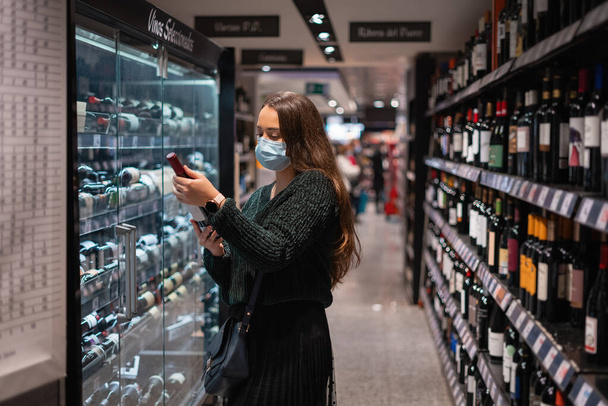 Woman choosing wine in shop - Photo, Image
