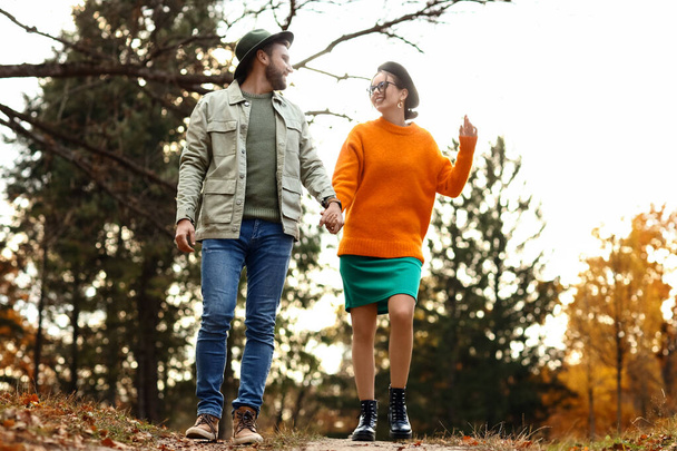 Hermosa pareja cogida de la mano y caminando en el parque de otoño - Foto, Imagen